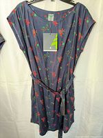 Full view of Woods navy floral dress on hanger showing belt and size tag