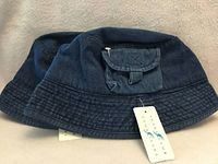 Two denim bucket hats stacked showing brim and tags