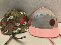 Front view of both infant hats showing designs and logo patches