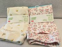 Front view of both packaged leggings with floral prints visible