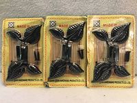 Three sealed retail packages of leaf-design black metal wall hooks, screws visible