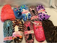 Group shot of 10 pairs assorted slippers showing colours and labels