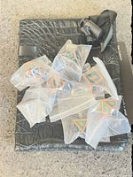 Seven individually bagged metal dice on top of black pouch