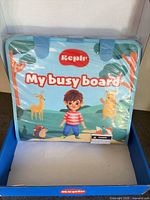 Box opened showing sealed felt busy board front cover