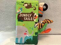 Front cover of green cloth book with elephant, monkey, bird and protruding animal tails
