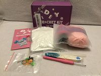 Entire kit with box, yarn, stuffing, tools and manual visible