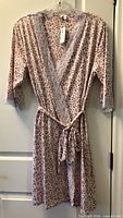 Front view of pink floral kimono robe with lace trim and belt