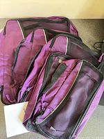 Five purple Bago packing cubes laid out