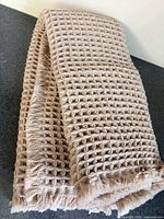 Folded beige waffle bath mat showing overall texture and color