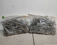 two zip-top bags filled with steel hooks