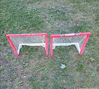 Front view of both Franklin NHL kid-size hockey nets on grass