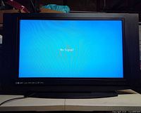 Front view of powered-on Olevia television displaying blue "No Signal" screen