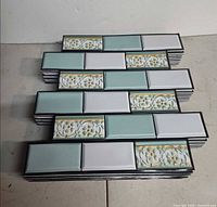 Stack of peel-and-stick tile sheets showing brick pattern and colors