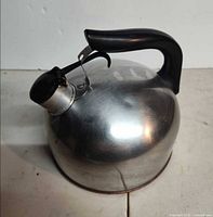 Side view of aluminum kettle showing handle, spout cap, and body condition