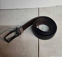 Coiled belt showing black exterior and buckle