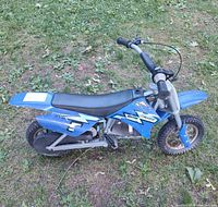 Left side view of blue Razor MX350 dirt bike showing body, seat, handlebars, rear wheel and frame