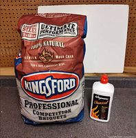 Kingsford 18 lb charcoal bag next to Wegmans 32 fl oz starter fluid