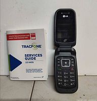 LG 440G flip phone open alongside TracFone services guide