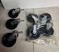 Three loose casters and sealed pack of four casters