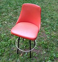 Full view of orange swivel chair on lawn