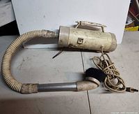 Full view of vacuum with hose and brush attachment
