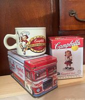 Tin, mug and boxed figurine group shot