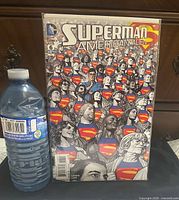 Front cover of Superman American Alien #6 next to water bottle for scale
