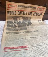 Front page with headline 'World Grieves for Kennedy' and visible wear