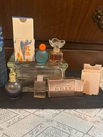 Overview of all perfume bottles and packaging on clear glass stand
