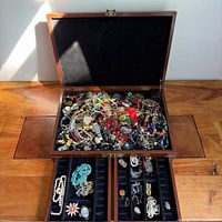 overall view of open jewelry box with drawers extended showing mixed jewelry contents