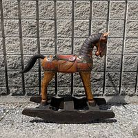 full view of carved wooden rocking horse on rocker base