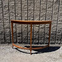 Front view of demilune console table showing overall form, legs, stretcher