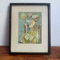 Full view of framed Picasso print on wood surface