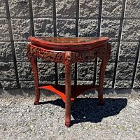 Front three-quarter view showing carved apron, legs, lower shelf