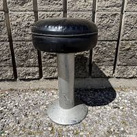Full side view of stool showing seat, column and base