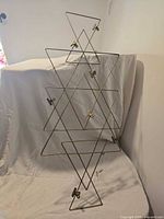 Front view of full geometric metal photo display showing brass finish and eight clips