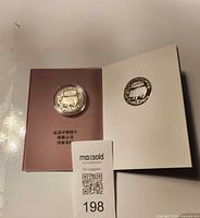 Coin in open presentation booklet