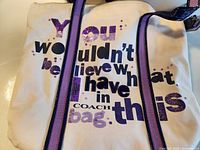 Front view of Coach tote bag with graphic text