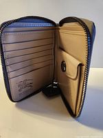 Wallet open showing card slots, coin pocket, logo stamp