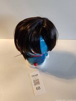 Front view of dark brown layered wig displayed on toy