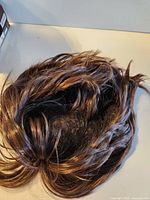 Wig laid flat showing interior mesh cap and hair fibers
