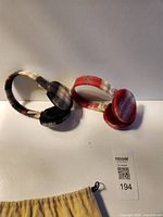 Two plaid ear muffs lying flat showing full view and colors