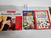 Front covers of guitar lesson set and two drawing books