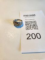 Top view of silver ring next to lot card