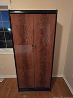 Front view of closed wardrobe showing woodgrain doors and black frame