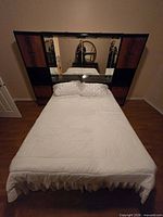 Front view of bed and mirrored headboard wall unit