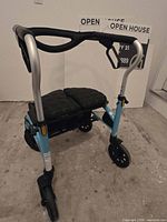 Full view of light blue rollator walker showing frame, wheels and seat