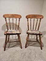 Front view of both spindle-back wooden chairs with cushions