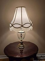 Lamp lit on table showing full view with shade and base