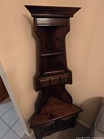Full view of tall wooden corner curio cabinet